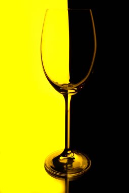 siyah ve sarı ışıklı bir arka plan ile Şarap kadehi