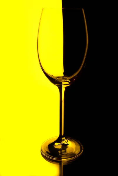 Copa de vino con fondo amarillo y negro iluminado — Foto de Stock