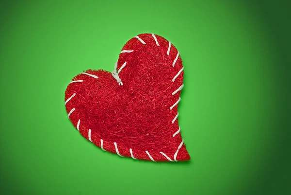 Красное сердце на зеленом фоне — стоковое фото