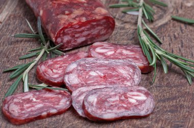 Salami on wooden background clipart