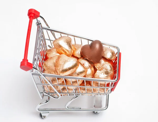 Dulce corazón de chocolate, lámina de oro envuelto corazones de chocolate y carrito de compras — Foto de Stock