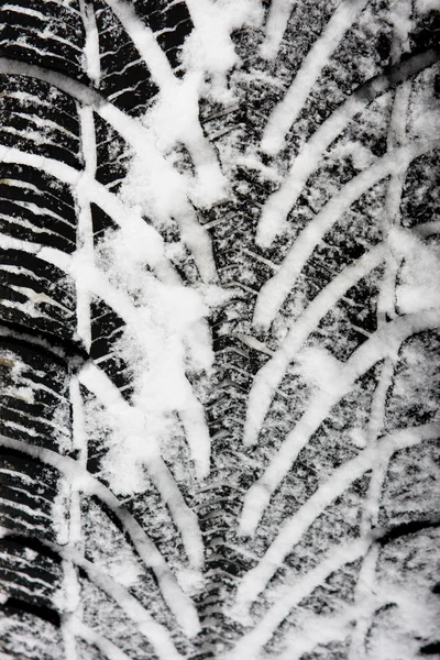 Pneus de carro em uma estrada nevada — Fotografia de Stock