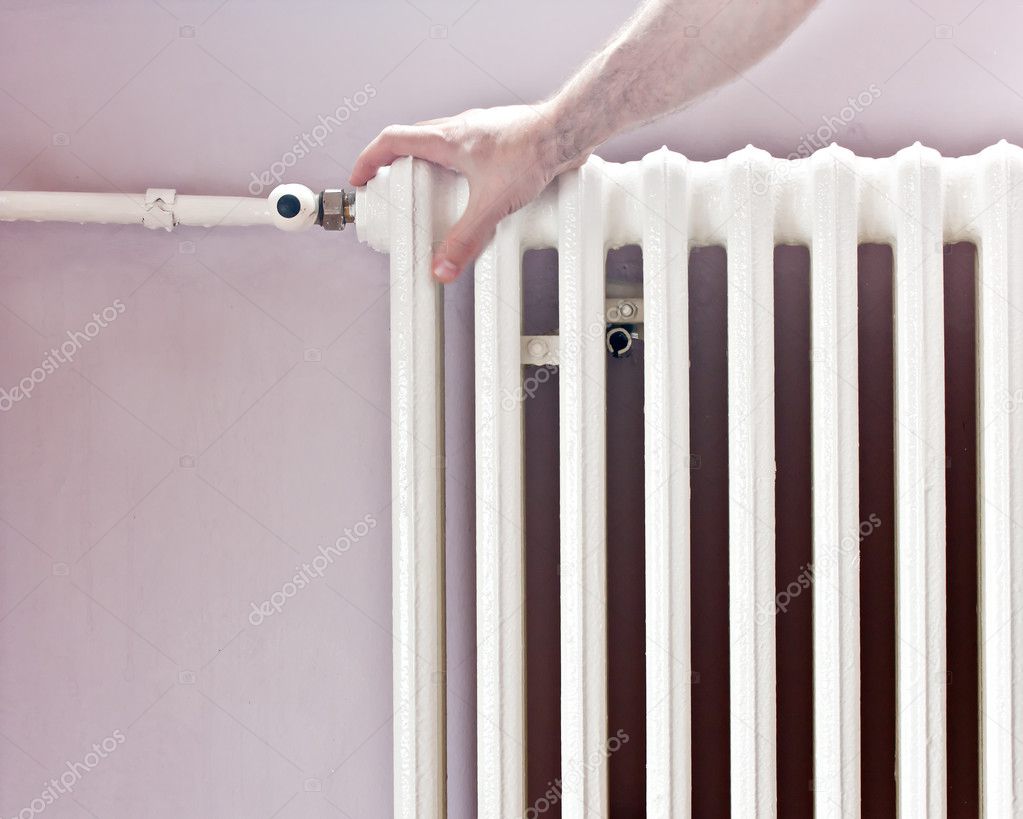 Hand at radiator of central heat energy Photo by 9666897