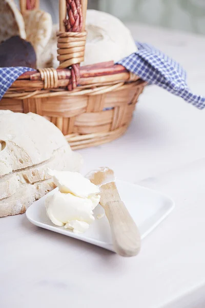 Fresh organic bread and butter in basket — Stock Photo, Image