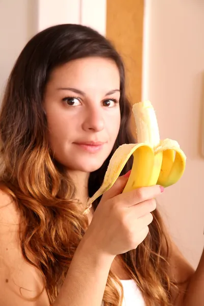 Jovem mulher comendo uma banana — Fotografia de Stock