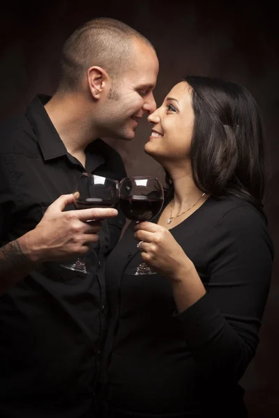 Szczęśliwy rasy mieszanej para flirty i gospodarstwa kieliszki do wina — Zdjęcie stockowe
