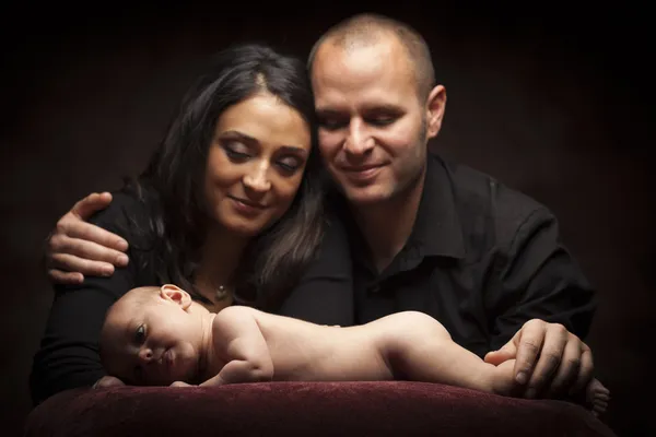 Casal de raça mista amorosamente olhar enquanto o bebê coloca no travesseiro — Fotografia de Stock