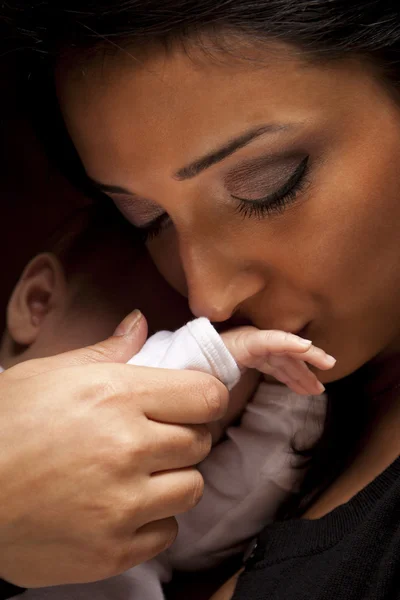 Mulher étnica beija sua mão recém-nascida do bebê — Fotografia de Stock