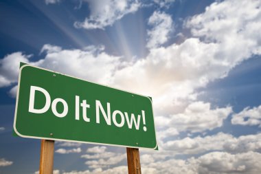 Do It Now! Green Road Sign and Clouds clipart