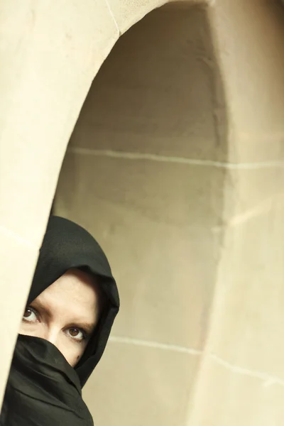 stock image Cautious Islamic Woman in Window Pane Wearing Burqa or Niqab