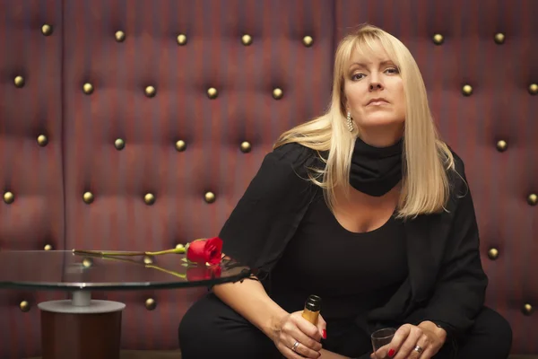 Sensuell blond kvinna sitter nära champagne och rose — Stockfoto