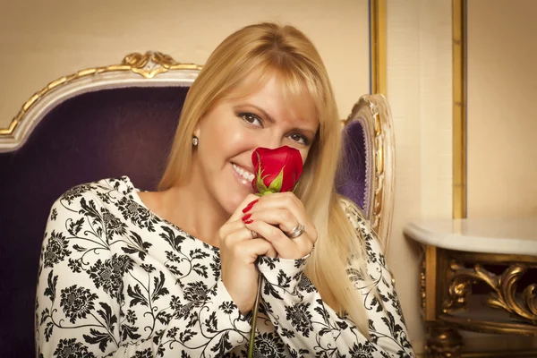 stock image Seated Woman Smiling While Smelling Red Rose