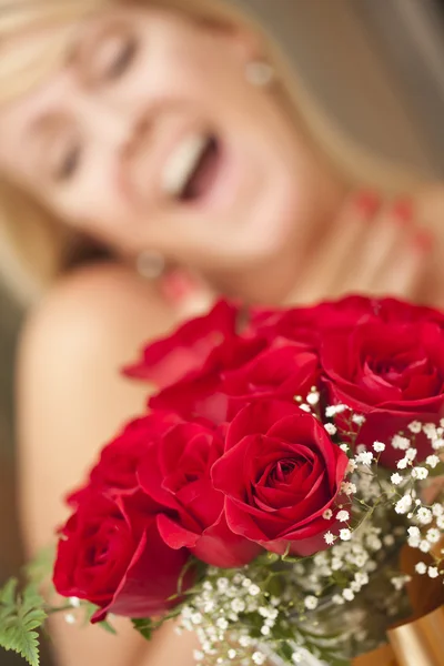 Ξανθιά γυναίκα δέχεται το δώρο των κόκκινων τριαντάφυλλων — Φωτογραφία Αρχείου