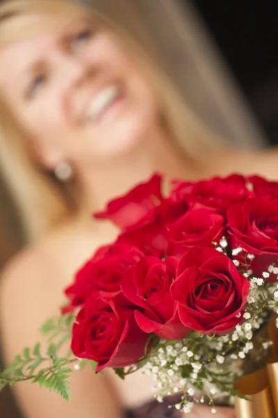 Mujer rubia acepta regalo de rosas rojas —  Fotos de Stock