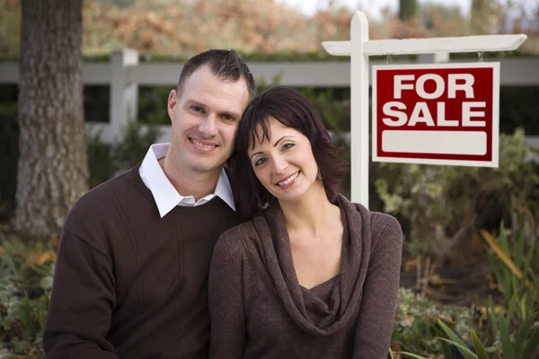 Lyckliga paret framför fastigheter tecken — Stockfoto
