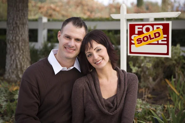 Casal feliz na frente do Sinal Imobiliário Vendido — Fotografia de Stock