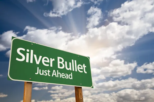 Silver Bullet Juste devant Green Road signe et nuages — Photo