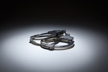 Abstract Pair of Handcuffs Under Spot Light clipart