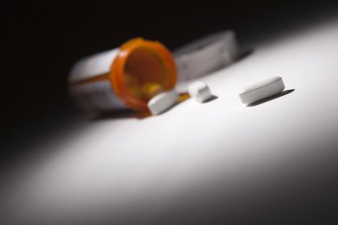 Medicine Bottle and Pills Under Spot Light clipart