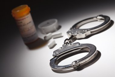 Handcuffs, Medicine Bottle and Pills Under Spot Light clipart