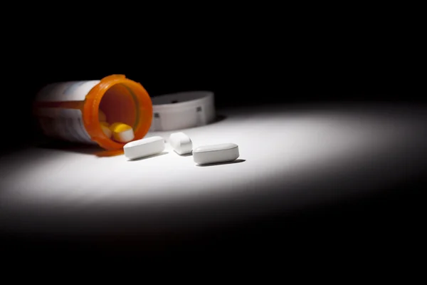 Gyógyszer palackot és tabletták Spot lámpa alatt — Stock Fotó