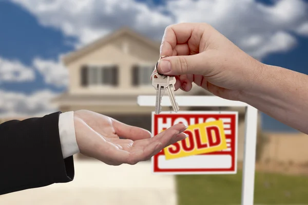 Передача ключей от дома перед продаваемым новым домом — стоковое фото