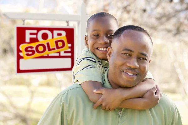 Padre e figlio di fronte al segno immobiliare venduto — Foto Stock