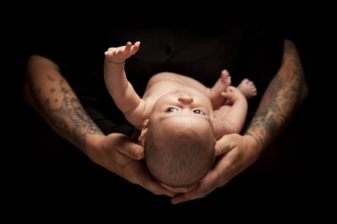 Hands of Father and Mother Hold Newborn Baby on Black clipart