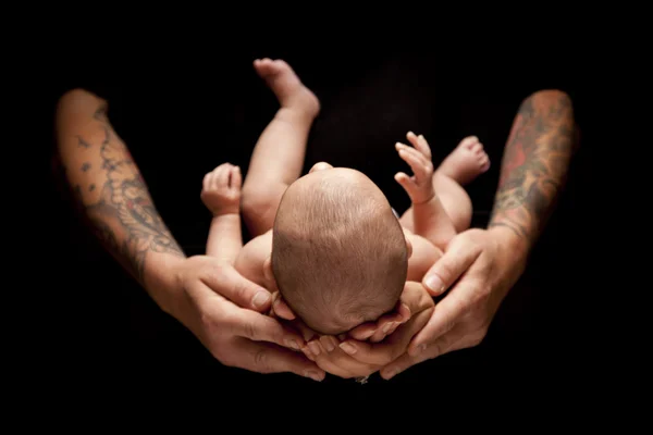 Hände von Vater und Mutter halten Neugeborenes auf schwarz — Stockfoto