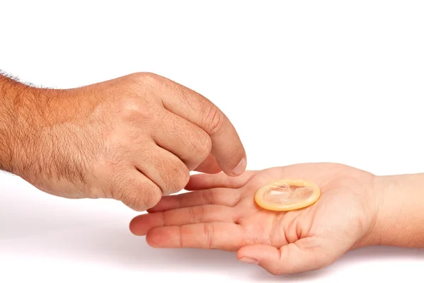 Αρσενικό χέρι λαμβάνοντας ένα προφυλακτικό από ένα γυναικείο χέρι — Φωτογραφία Αρχείου