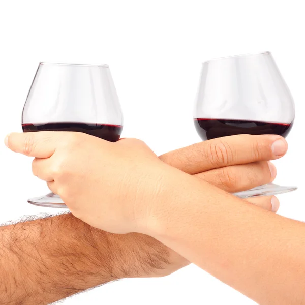 Δύο χέρια που κρατούν τα κόκκινα γυαλιά κρασιού — Φωτογραφία Αρχείου