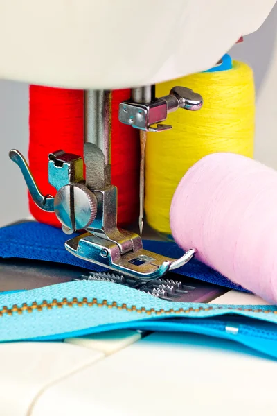 Máquina de costura, bobinas com rosca e zíperes — Fotografia de Stock