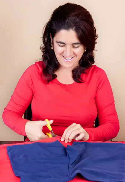 Hispanic woman cutting a piece of fabric — Stock Photo, Image