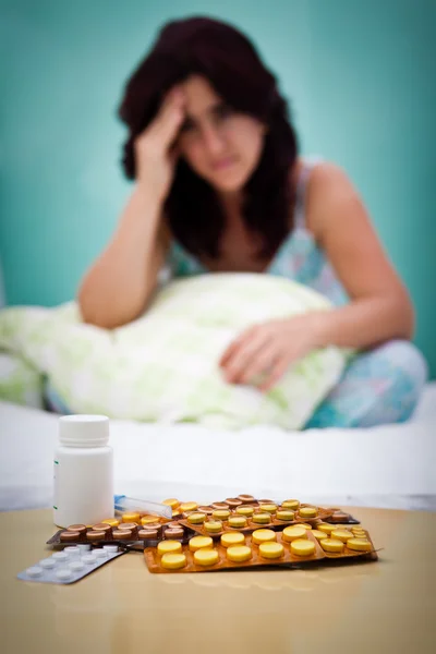 Таблетки и не в фокусе больная или депрессивная женщина — стоковое фото