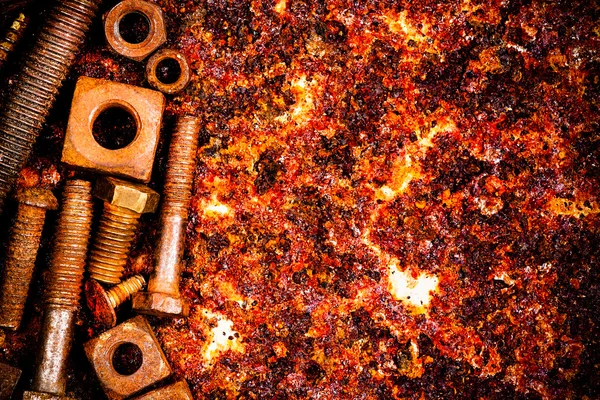 Nuts and bolts on a rusty background — Stock Photo, Image
