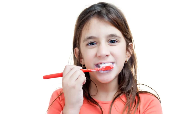 Маленькая латинская девочка стирает зубы изолированно на белом — стоковое фото
