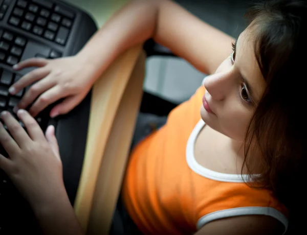 Pequena menina hispânica estudando em um computador em casa — Fotografia de Stock