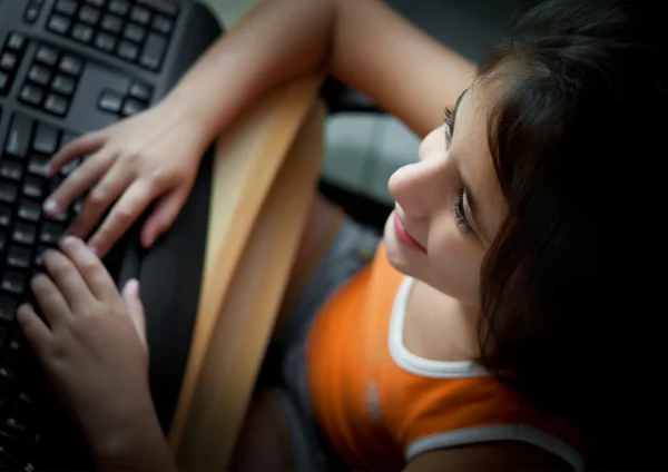 Kleine Spaanse meisje studeren op een computer thuis — Stockfoto