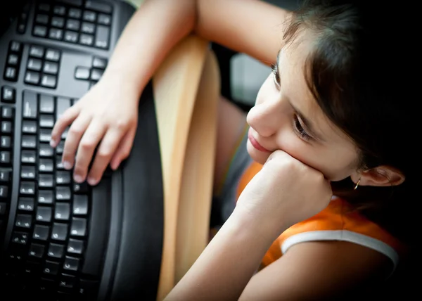 Små spansktalande tjej som studerar på en dator hemma — Stockfoto