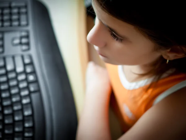 Kleine Spaanse meisje studeren op een computer thuis — Stockfoto