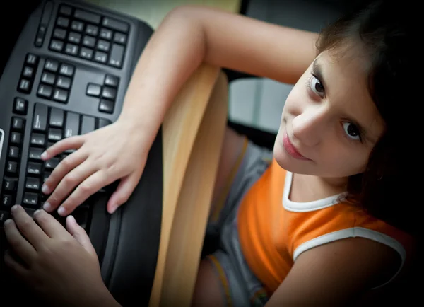 Маленькая латиноамериканка учится дома за компьютером — стоковое фото