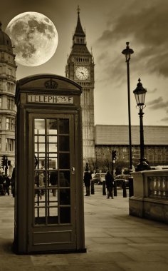 Vintage sepia image of the Big Ben in London with a typical red phone booth clipart