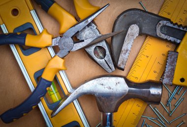 Set of tools over a wooden panel clipart