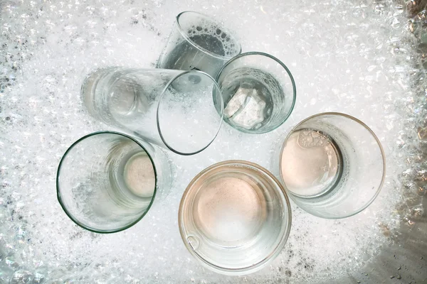 Wassen van de vuile bril op zeepwater — Stockfoto