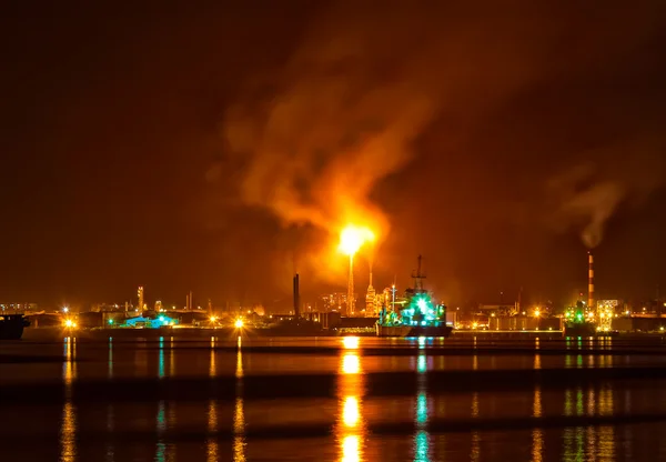 Ölraffinerie in der Nacht mit einer riesigen Rauchsäule, die die Atmosphäre verschmutzt — Stockfoto