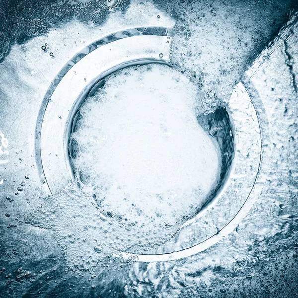 Detergente e bolhas de água descendo a pia — Fotografia de Stock