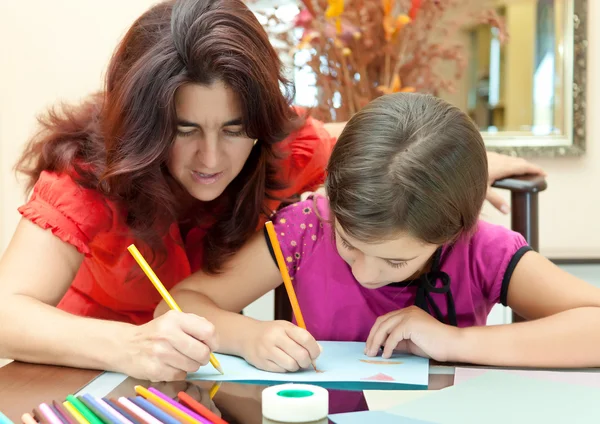 Latin mamma att hjälpa dottern med hennes konst skolprojekt — Stockfoto