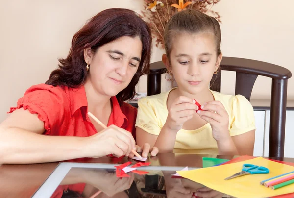 Mãe latina ajudando sua filha com seu projeto de arte escolar — Fotografia de Stock