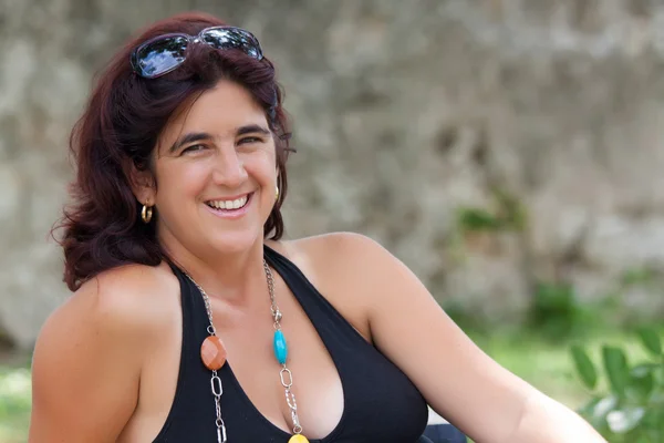 Schöne lateinische Frau sitzt in einem Park — Stockfoto