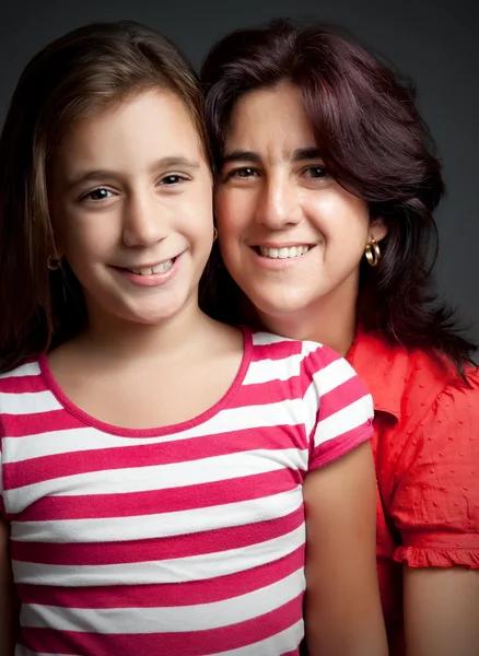 Hispanic mother and daughter on a dark background — Stock Photo, Image